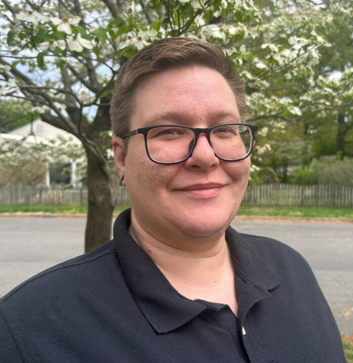 Quinn Bracken Photo of Quinn, a non-binary person with light hair and glasses.